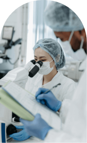 Woman in lab looking into a microscope